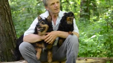 köpeklerle oturan gri saçlı adam