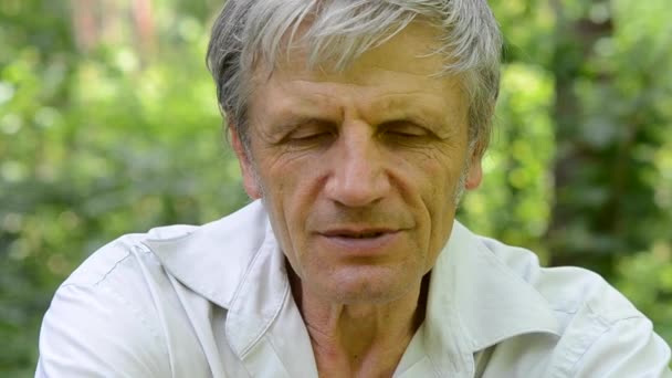 Retrato de hombre de pelo gris con arrugas, que cuenta la historia — Vídeos de Stock