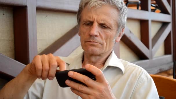 Alter Mann mit dem Telefon in Nahaufnahme — Stockvideo
