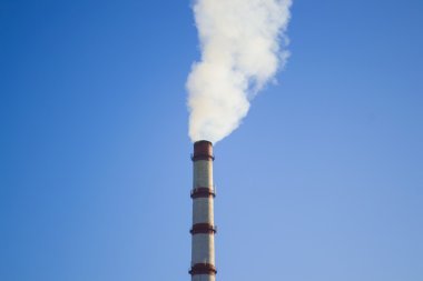Dumanlı borunun ucunda mavi gökyüzü