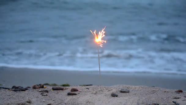 Fuoco del Bengala che brucia sul mare spiaggia primo piano. Sfondo vacanza romantico. — Video Stock