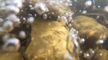 Dağ nehrinin dibindeki taşlar ve hava kabarcıkları