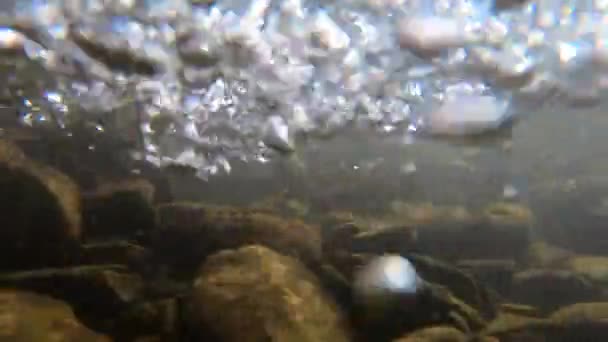 Pierres au fond d'une rivière de montagne et bulles d'air — Video