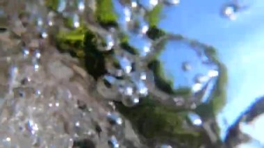 Bir dağ nehrinin güçlü bir akışının hava kabarcıklarıyla soyut su manzarası