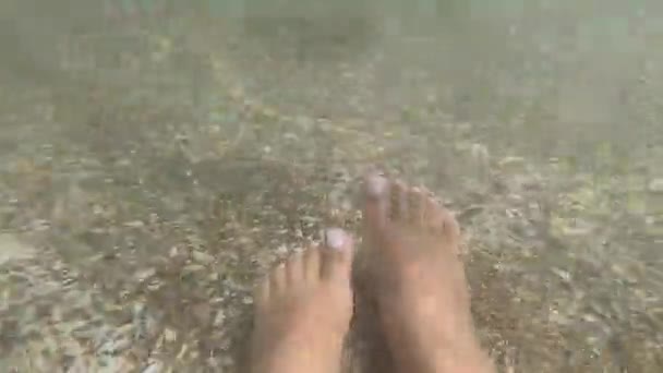 Zwei weibliche Füße im sauberen und transparenten Wasser am Sandstrand — Stockvideo