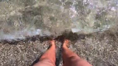 Kumsalda bir kız duruyor kumlu ve kabuklu.