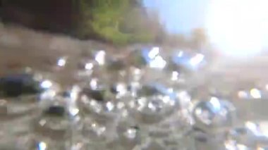 Bir dağ nehrinin güçlü bir akışının hava kabarcıklarıyla soyut su manzarası