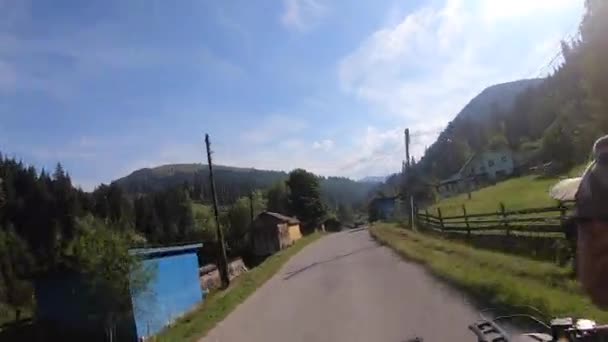 El hombre monta en quad negro o ATV en carretera en el pueblo de montaña en verano — Vídeo de stock