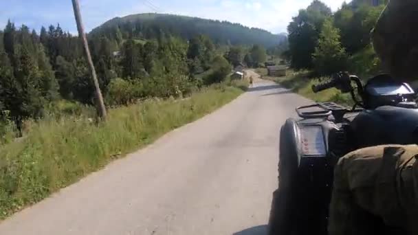 Lány és férfi lovaglás quad kerékpár vagy ATV földúton hegyi faluban, — Stock videók