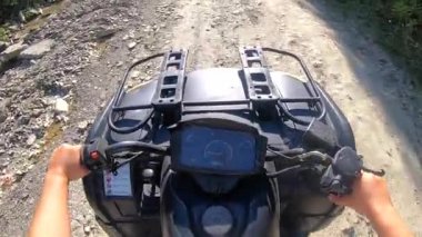 Adam dört tekerli bisiklete ya da ATV 'ye biniyor. POV, yukarıdan görünüm.