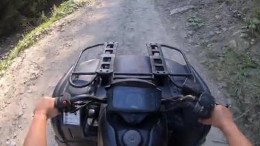 Adam dört tekerli bisiklete ya da ATV 'ye biniyor. POV, yukarıdan görünüm.