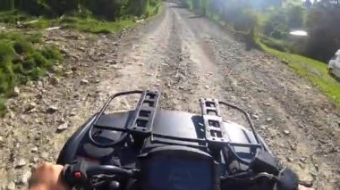Adam dört tekerli bisiklete ya da ATV 'ye biniyor. POV, yukarıdan görünüm.