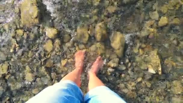 Meisje staat op de bodem van een rotsachtige ondiepe rivier in de bergen — Stockvideo