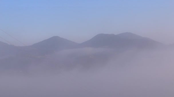 O nevoeiro da manhã dissipa-se nas montanhas dos Cárpatos. Movimentos de nevoeiro matinal — Vídeo de Stock