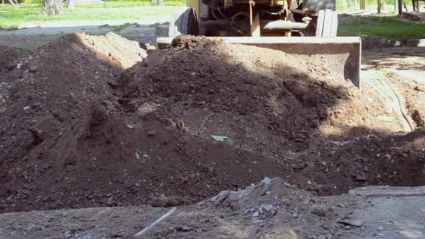 Traktor entfernt Bodenverschmutzung, gräbt Loch in Baustelle. — Stockvideo