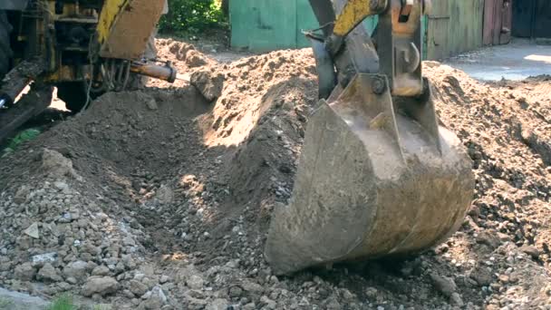 Bagger türmen den Boden aus nächster Nähe auf. Alter Traktor bei Wartungsarbeiten. — Stockvideo