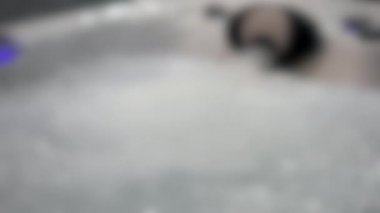 Arka plan bulanık. Seri, jakuzi şelalesi banyosu ve suya yakın çekim.