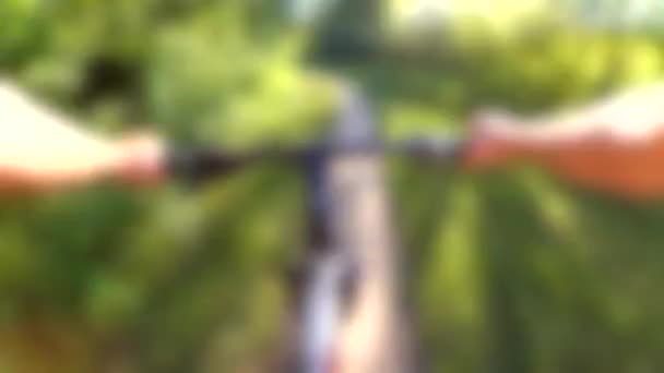 背景がぼやけている。極端な女の子は川の岸に沿って自転車に乗る. — ストック動画