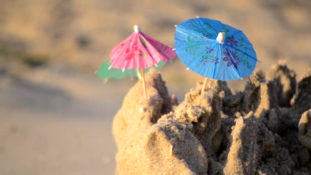 Pequeñas sombrillas de papel para un puesto de cócteles en la playa de arena — Vídeos de Stock