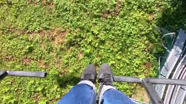Girl rides or climbs on lift or cable car up mountain. — Stok Video