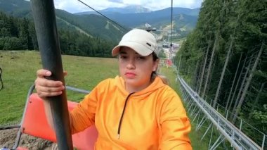 Kız ya asansöre biner ya da teleferiğe biner ya da dağa tırmanır.