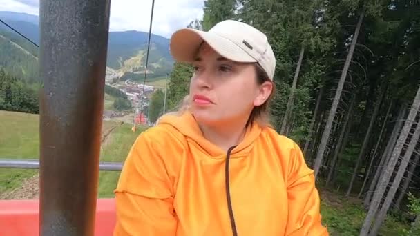 Girl rides or climbs on lift or cable car up mountain. — Stock Video