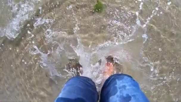 Ragazza si trova a piedi nudi e salti, spruzzando acqua sulla spiaggia di sabbia — Video Stock