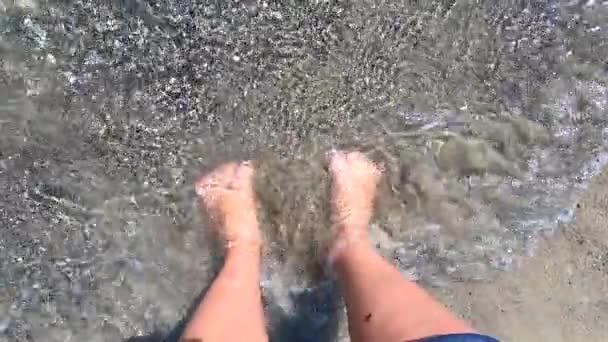 Ragazza si trova a piedi nudi sulla spiaggia di sabbia e seppellisce le dita nella sabbia — Video Stock