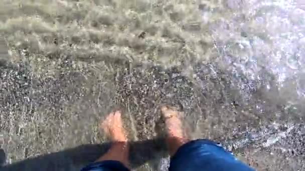 Meisje staat blootsvoets op zandstrand en begraaft zijn vingers in het zand — Stockvideo