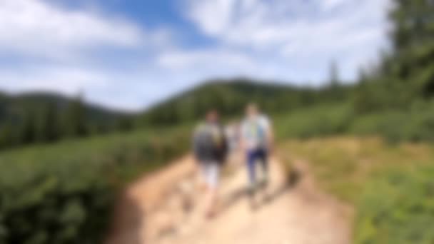 Blurred background. People walk on dirt mountain trail while hiking in mountains — Stock Video