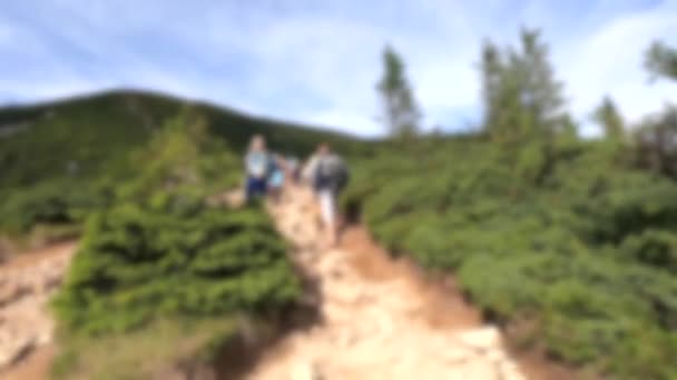Zamazane tło. Ludzie chodzą po brudnej ścieżce górskiej podczas wędrówki w górach — Wideo stockowe