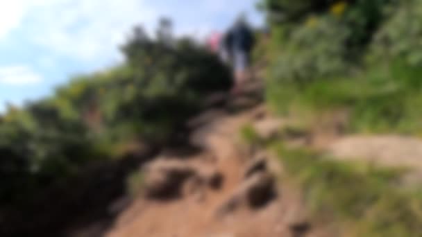Homályos háttér. Az emberek gyalogolnak a földúton hegymászás közben. — Stock videók