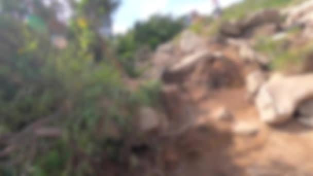 Blurred background. People walk on dirt mountain trail while hiking in mountains — Stock Video