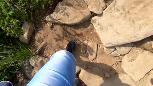 사람은 여름날 돌을 가지고 비포장도로를 따라 산을 올라간다 — 비디오