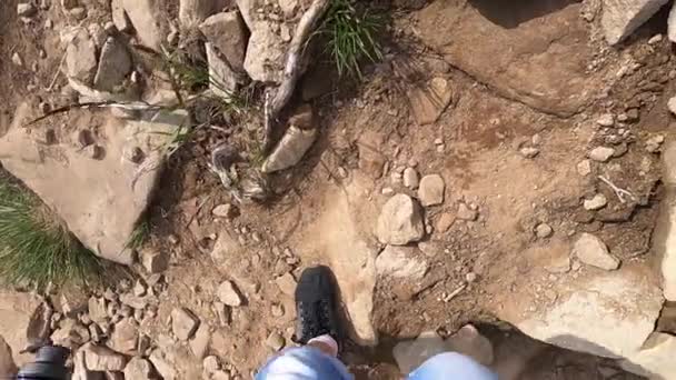 Homem sobe a montanha em uma estrada de terra com pedras dia de verão — Vídeo de Stock