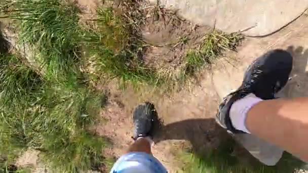 Man climbs up the mountain on a dirt road with stones summer day — Stock Video