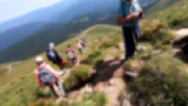 Blurred background. Person go down mountain. People walk on dirt mountain trail — Stock Video