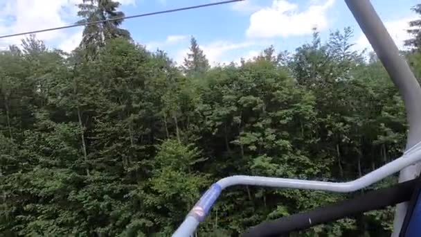 Ropeway movement in forest in mountains on sunny day. Side view. — Stock Video