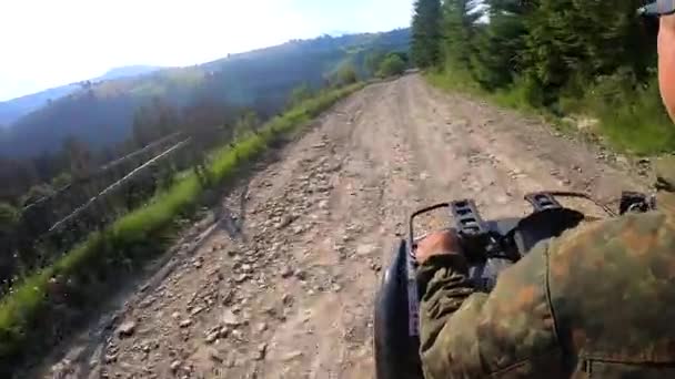 男は晴れた夏の日に山の上に未舗装の道路でクワッドバイクに乗る — ストック動画