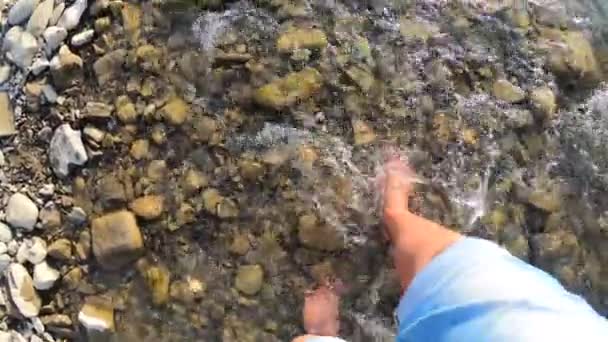 Chica caminando descalza sobre piedras de río poco profundo primer plano, día de verano soleado — Vídeos de Stock