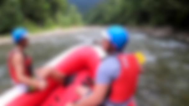 Rafting blurred background. Men sit in red inflatable boat, paddle — Stock Video