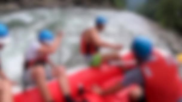 Rafting arrière-plan flou. Les hommes s'assoient dans le bateau gonflable rouge, pagaie — Video