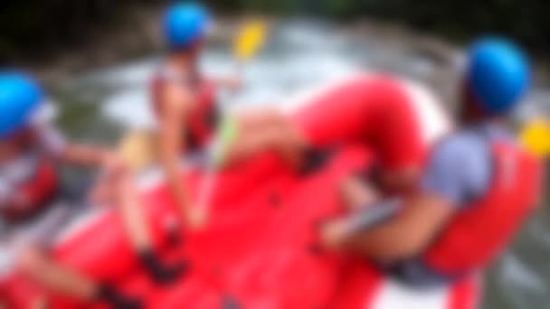 Rafting zamazane tło. Mężczyźni siedzą w czerwonej nadmuchiwanej łodzi, wiosła — Wideo stockowe