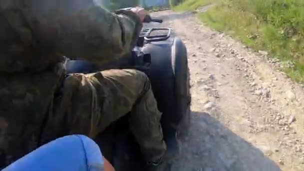 Hombre montando quad bike en camino de tierra en la cima de la montaña en el soleado día de verano — Vídeo de stock