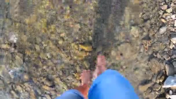 Ragazza che cammina a piedi nudi su pietre di fiume poco profondo primo piano, giornata estiva soleggiata — Video Stock