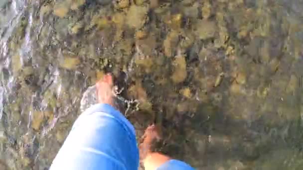 Mädchen läuft barfuß auf Steinen des flachen Flusses in Nahaufnahme, sonniger Sommertag — Stockvideo