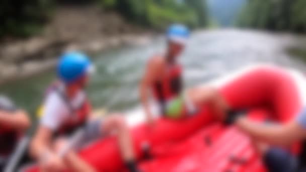 Forsränning suddig bakgrund. Män sitter i röd uppblåsbar båt, paddla — Stockvideo