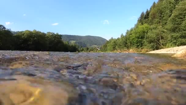 Caudal de agua del río de montaña, vista sobre la superficie del agua, cerca de la superficie del agua. — Vídeos de Stock