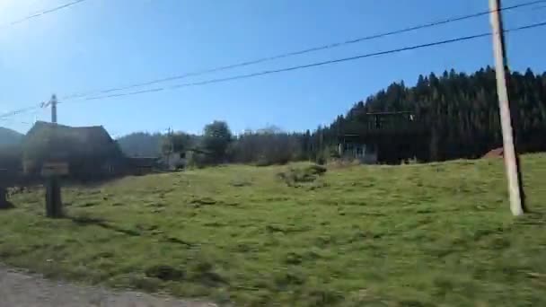 Blick aus dem Busfenster. Auto fährt auf Straße in Wald und Stadtbergen — Stockvideo