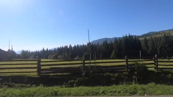 Vue depuis la fenêtre du bus. La voiture roule sur la route dans la forêt et les montagnes de la ville — Video